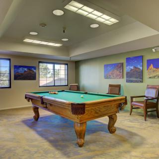 A cozy game room featuring a pool table and framed photographs on the walls.