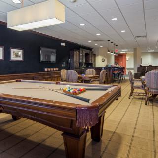 A spacious billiard room with a pool table and comfortable seating area.