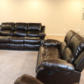 A living room featuring leather sofas arranged for comfortable seating.