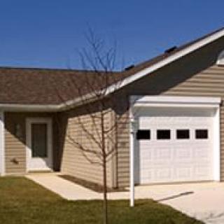A single-story suburban house with an attached garage and a small front yard.