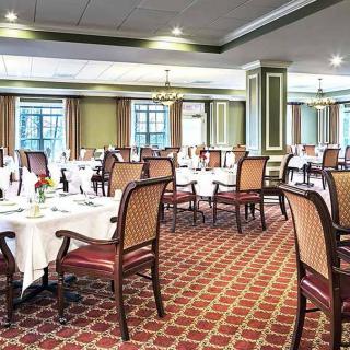 An elegant restaurant dining area with neatly arranged tables and chairs on a patterned carpet.
