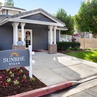 The exterior entrance of Sunrise Villa with neatly maintained landscaping.