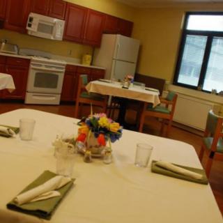 A cozy kitchen and dining area with a table set for a meal, featuring floral decorations.