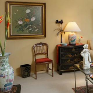 A cozy living room featuring elegant decor, including a large vase, framed artwork, and a stylish lamp.