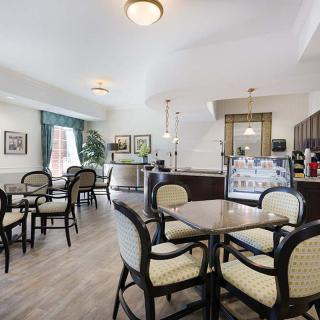 A cozy cafe interior with tables and chairs, featuring natural light and a welcoming atmosphere.