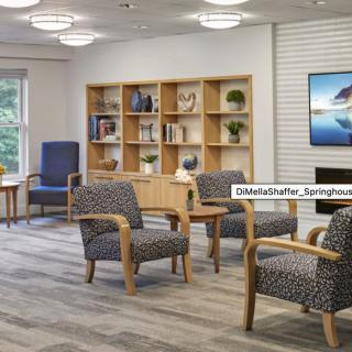 A modern lounge area with comfortable seating and a bookshelf for relaxation.