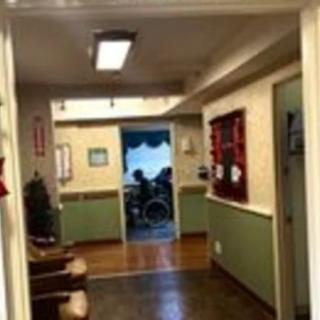 A view down a hallway with a wheelchair visible in the distance.