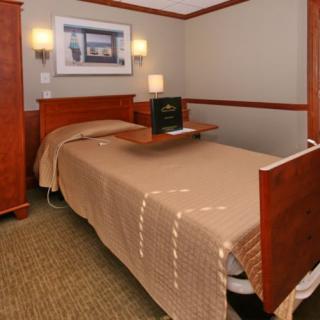 A hospital room featuring a single bed and basic amenities.