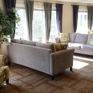 A bright living room with modern furniture and large windows letting in natural light.