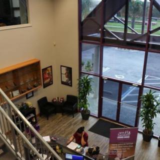 A spacious lobby with a reception desk, large windows, and a waiting area.