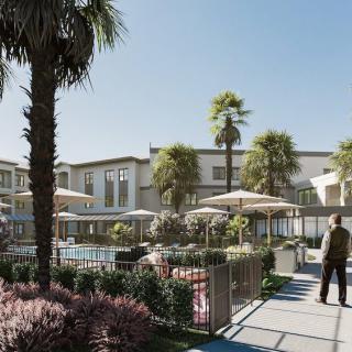 A sunny day at a modern resort featuring a swimming pool and outdoor leisure area surrounded by palm trees.
