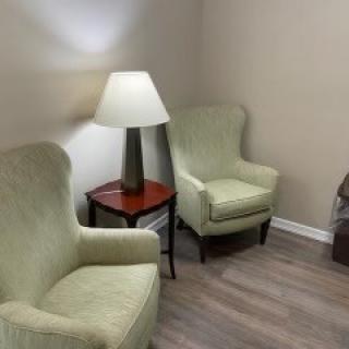 A cozy corner with two armchairs, a lamp, and a side table.