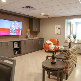 A modern living room with comfortable seating, a large wall-mounted television, and stylish decor.