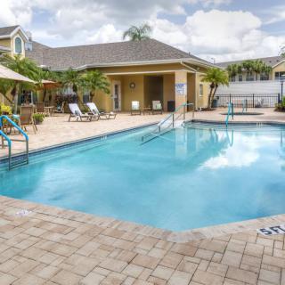 A serene outdoor pool area with loungers and sunshades, perfect for a tropical vacation.