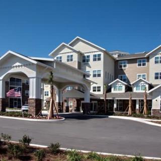 A large residential or hotel building with an entrance driveway and landscaped surroundings.