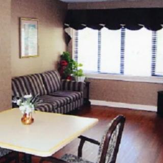 A cozy living room with a striped couch and large windows.