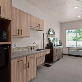 A modern kitchen with wooden cabinets and a large window.