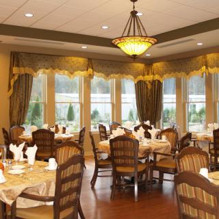 An elegant dining room with beautifully arranged tables and warm lighting.
