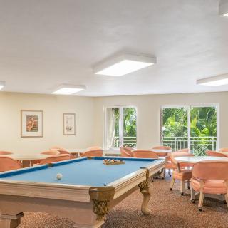 A bright and spacious game room featuring a pool table and seating area.