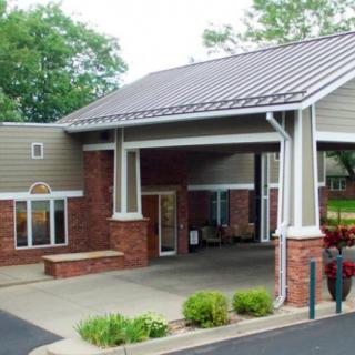 A small building with a covered entrance and brick exterior.