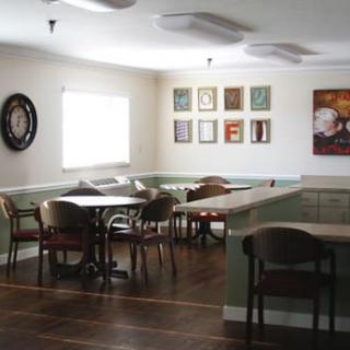 An empty dining area with tables, chairs, and wall art.