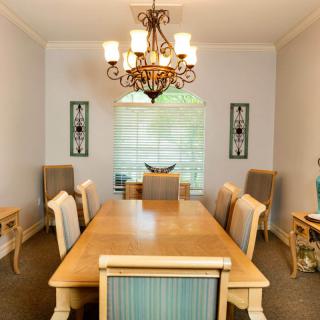 Elegant dining room with a wooden table, upholstered chairs, and a decorative chandelier.