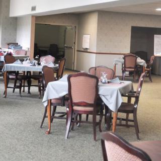 An empty dining room with neatly arranged tables and chairs.