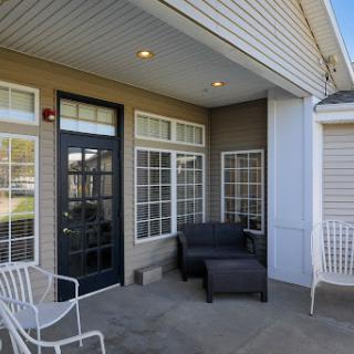 A cozy outdoor patio featuring modern furniture and a welcoming entrance.