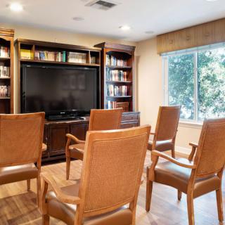 A cozy room setup with chairs facing a television and bookshelves.