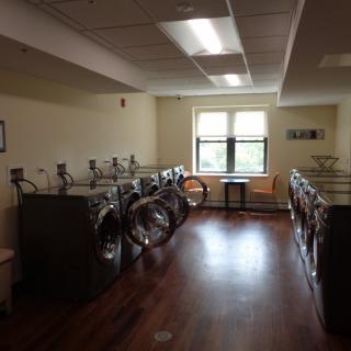A spacious laundry room with multiple washing machines and dryers.