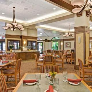 Spacious dining area with elegant chandeliers and wooden furniture.