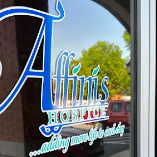 Window signage for Affinis Hospice, emphasizing their commitment to adding meaningful days.