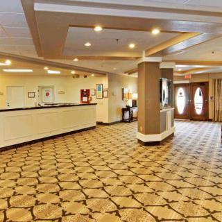 A spacious hotel lobby with a reception desk and decorative lighting.