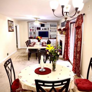 A cozy dining room with a round table set for a meal, featuring elegant decor and floral accents.