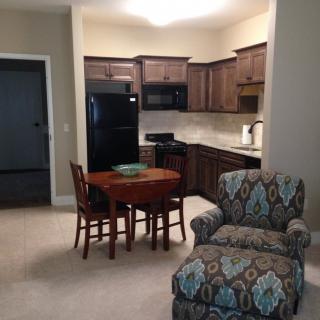 A cozy apartment interior featuring a compact kitchen and dining area.