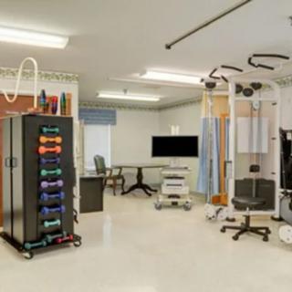 A modern hospital treatment room equipped with various medical devices and rehabilitation equipment.