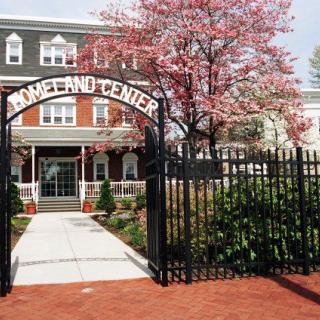 Entrance of a center with an iron gate and blooming trees.