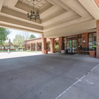 The entrance to a building with a covered driveway and glass doors.