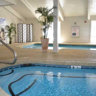 An inviting indoor swimming pool and hot tub area with lush plants.
