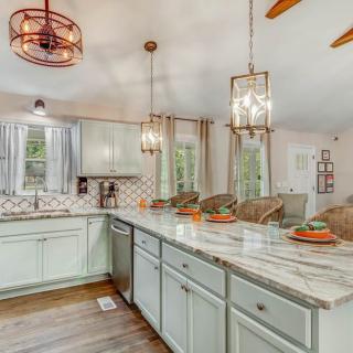 A modern kitchen with an open layout, featuring elegant pendant lighting and a spacious countertop.