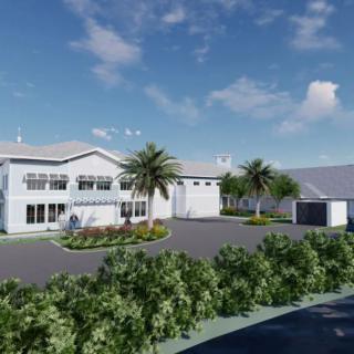 A modern residential house with palm trees and a driveway under a clear blue sky.