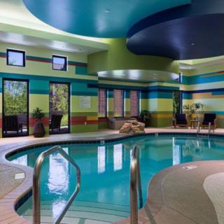 A modern indoor swimming pool area with colorful walls and contemporary design.