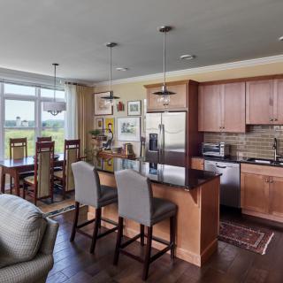 Contemporary kitchen and dining area with an open floor plan, featuring modern decor and stainless steel appliances.