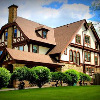 A beautifully designed historic mansion with intricate architectural details, surrounded by lush greenery.