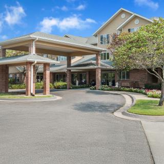 A residential building with a covered entrance and landscaped surroundings.