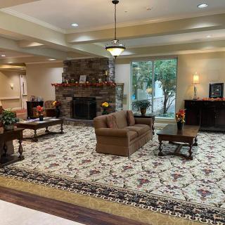 A cozy lobby with comfortable seating, a fireplace, and large windows providing natural light.