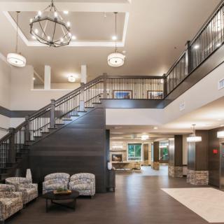 A spacious and modern lobby with a grand staircase and elegant lighting.