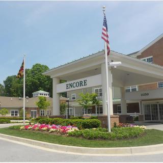 Entrance of a healthcare facility with flags and landscaped surroundings.
