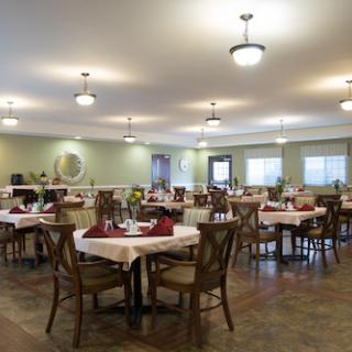A spacious and inviting dining area with neatly arranged tables and warm lighting.