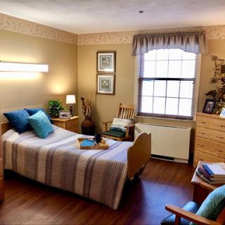 A cozy and well-decorated bedroom featuring a single bed, warm lighting, and personal touches.